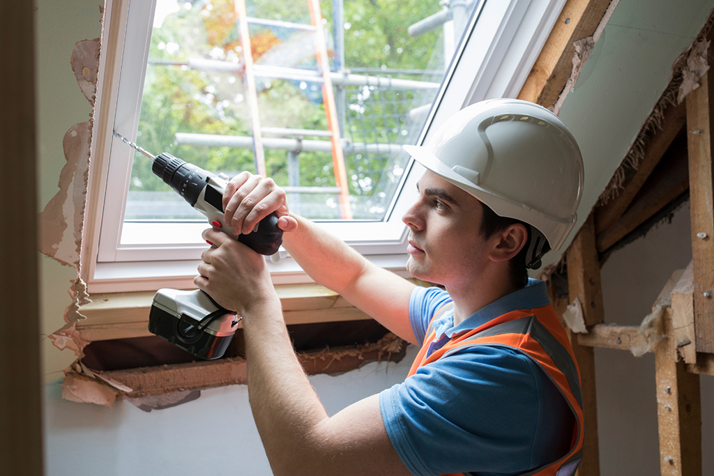 A contractor installs a window